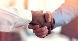 Employees of a business associate and a covered entity shake hands.