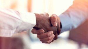 Employees of a business associate and a covered entity shake hands.