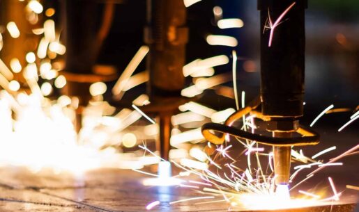 Manufacturing equipment cutting metal with sparks.